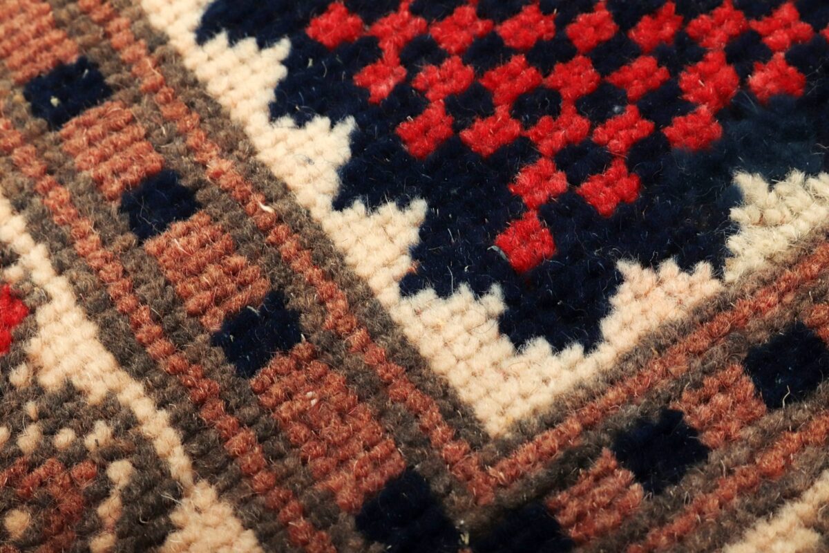 Handwoven wool rug detail in red, navy and cream
